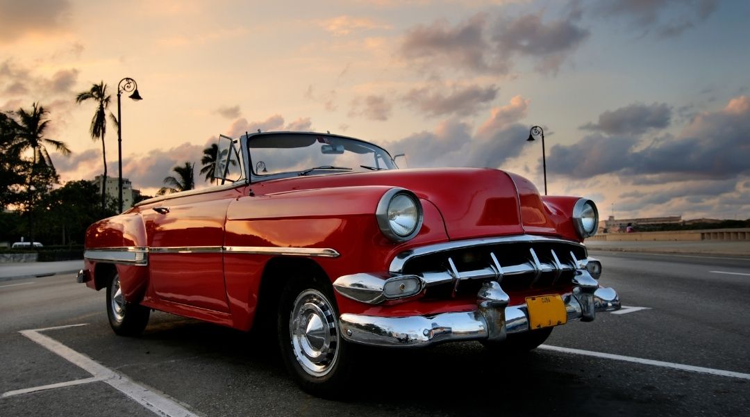 carro antigo e vermelho nas ruas de havana próximo a praia. melhor seguro para carro