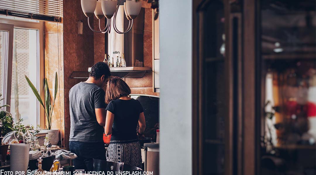 Jovem casal de costas para câmera em sua casa, abraçados e pensando na vida